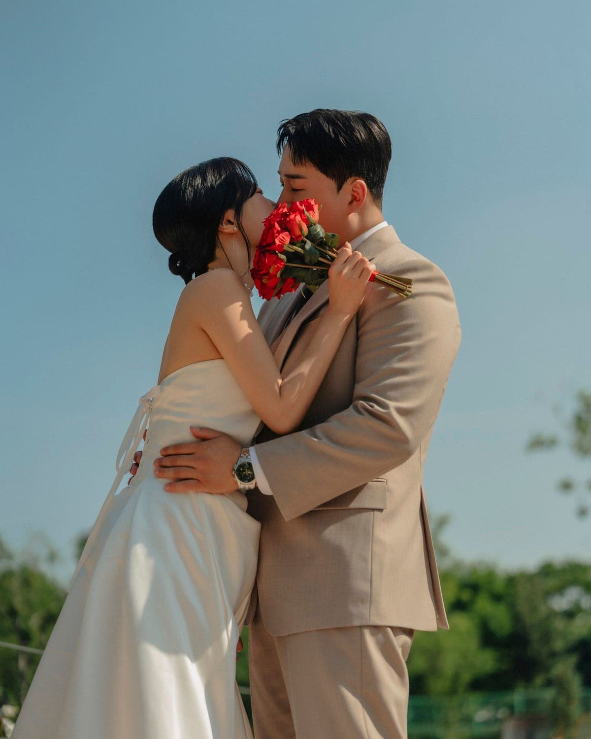 장미 부케를 들고 마주 안은 신랑과 신부